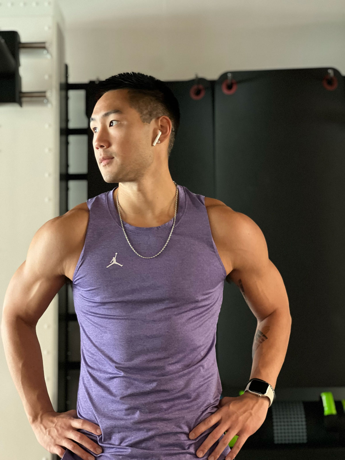 Coach posing for a photo in a gym, looking sideways.